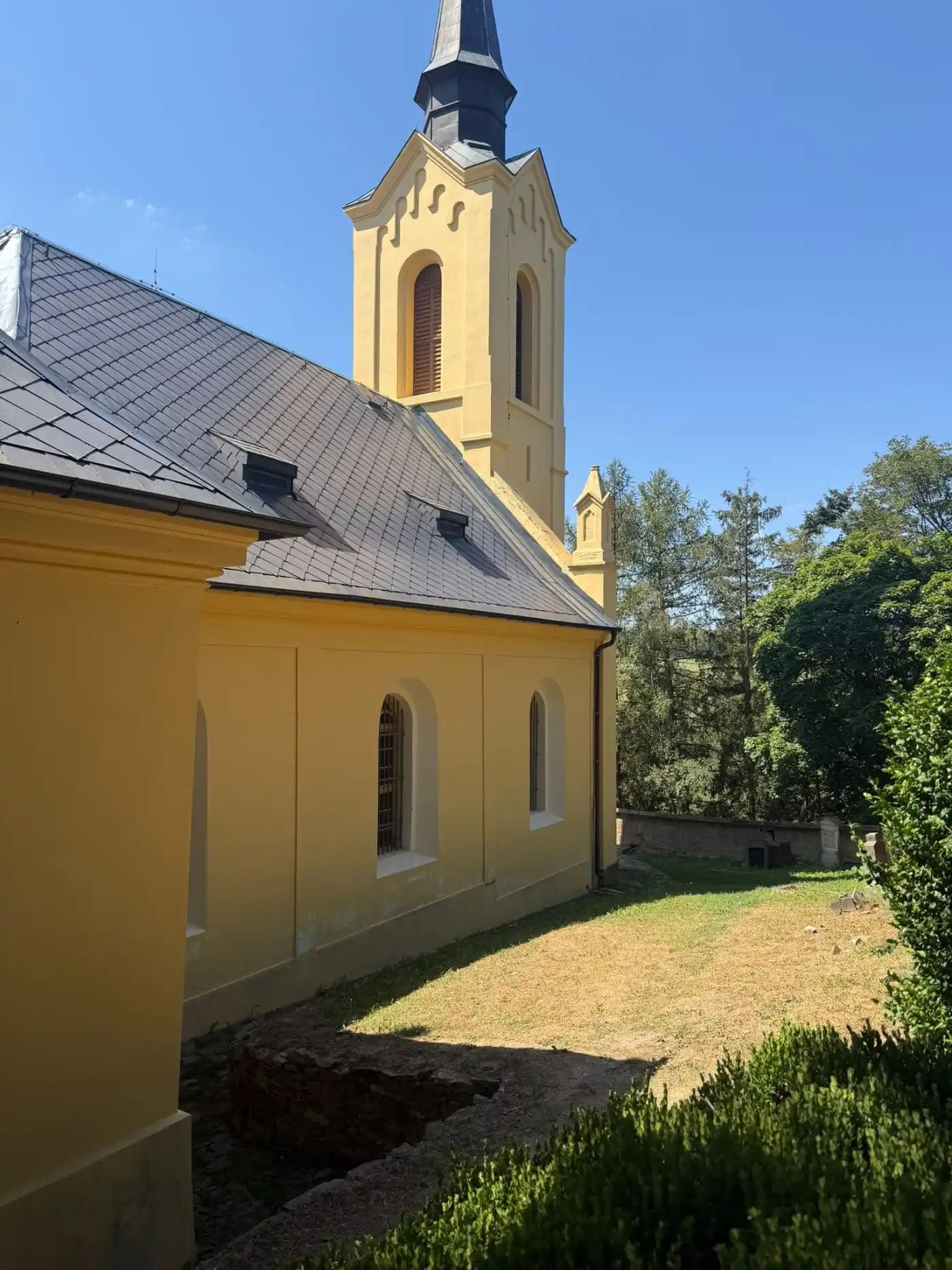 Außenansicht der Geisterkirche Lukova mit gelb gestrichener Fassade und restauriertem Dach