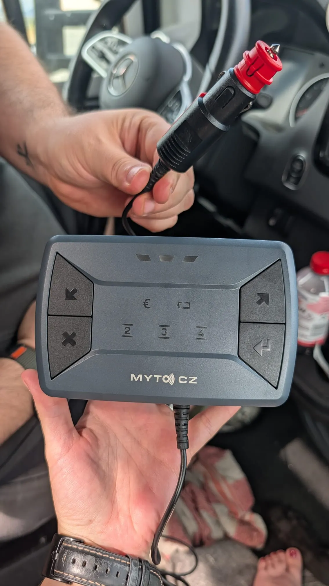 MYTO CZ Mautbox für Tschechien in der Hand — Bedientasten mit Achszahl-Anzeige (2/3/4) und Zigarettenanzünder-Stecker