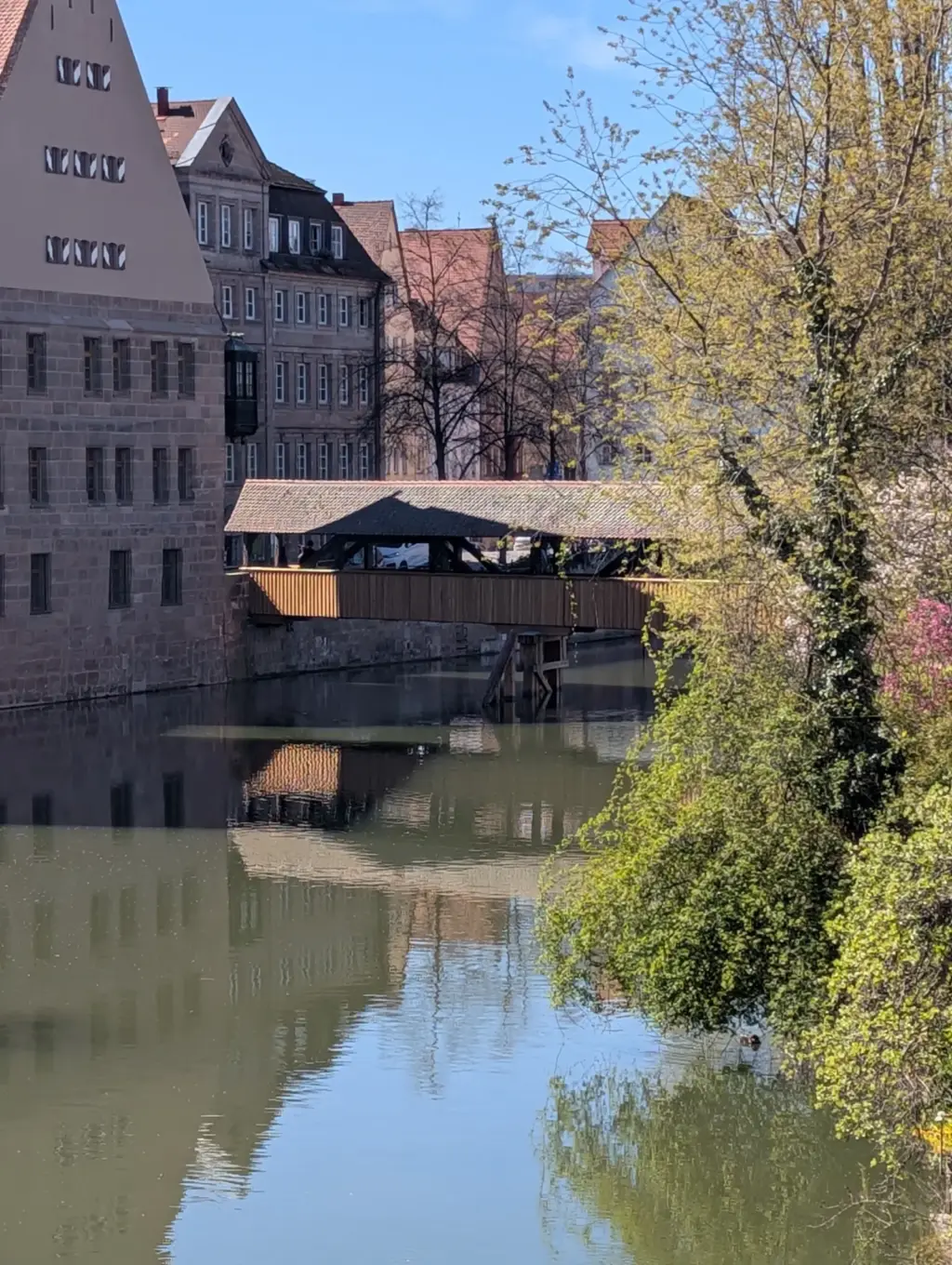 Historische Altstadt mit Fachwerkhäusern und überdachter Holzbrücke am Fluss