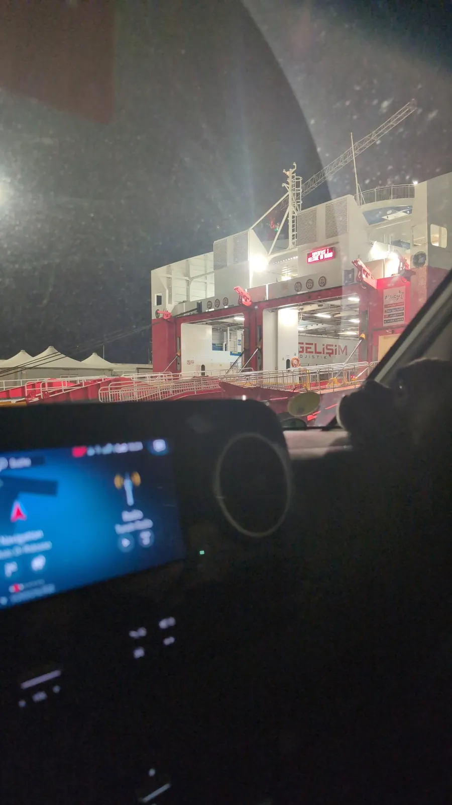 Blick aus dem Wohnmobil auf die offene Heckklappe der Superfast III bei Nacht im Hafen Bari